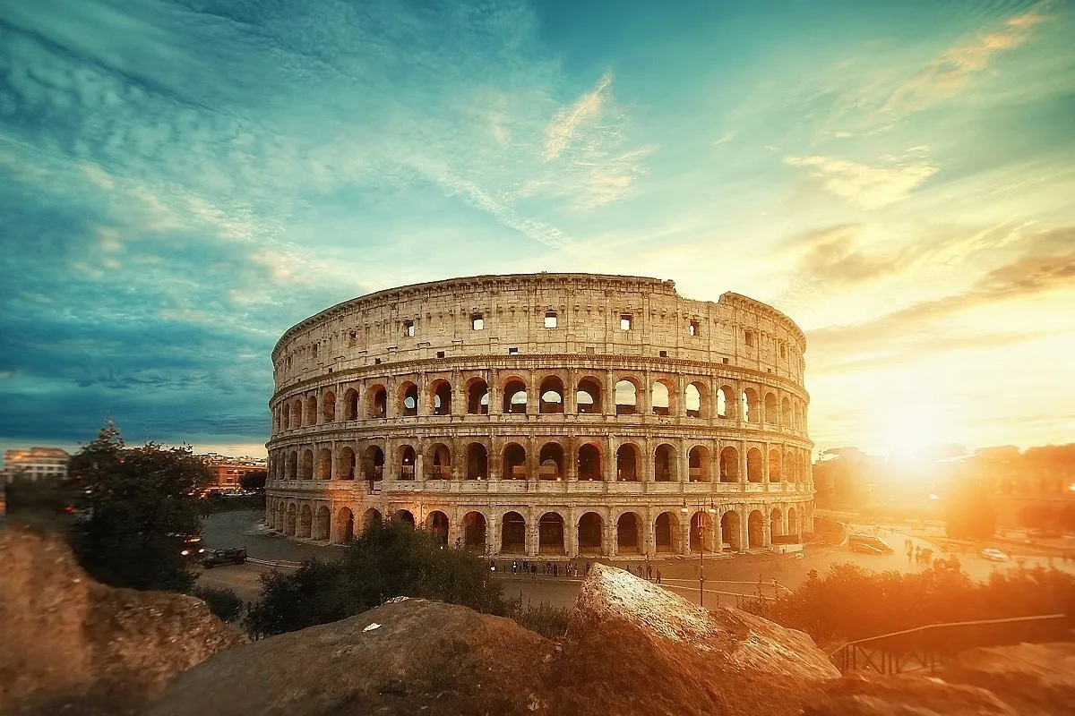 The Colosseum at sunrise, bathed in golden Roman light